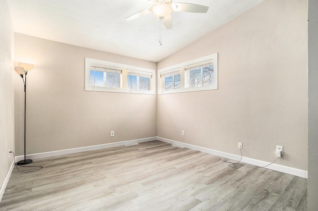 empty room with lofted ceiling, ceiling fan, baseboards, and wood finished floors