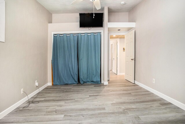 spare room with a ceiling fan, baseboards, and wood finished floors