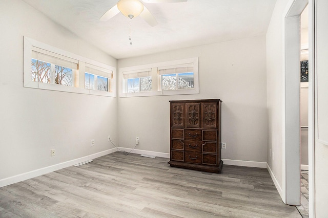 spare room with light wood-style flooring, visible vents, baseboards, and a ceiling fan