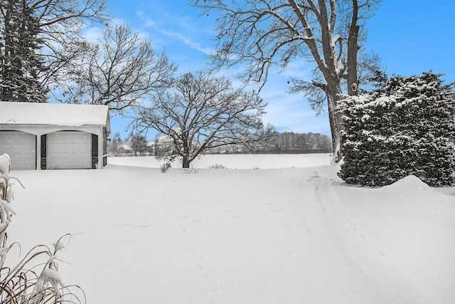 yard layered in snow with a garage