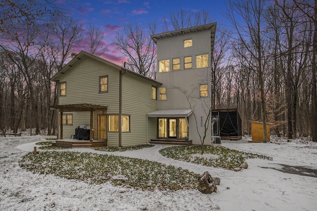 snow covered house featuring a pergola