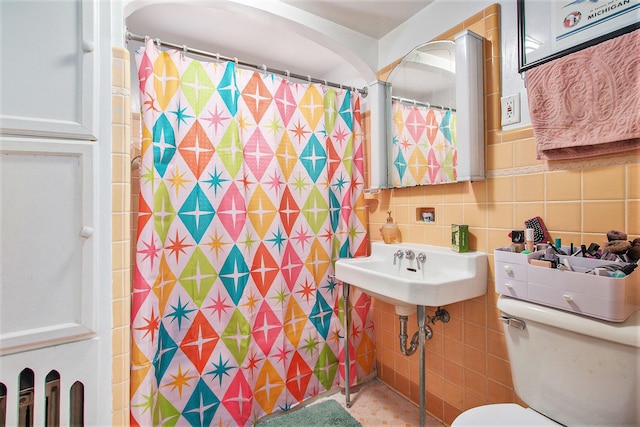 bathroom with tile walls, toilet, and a shower with shower curtain