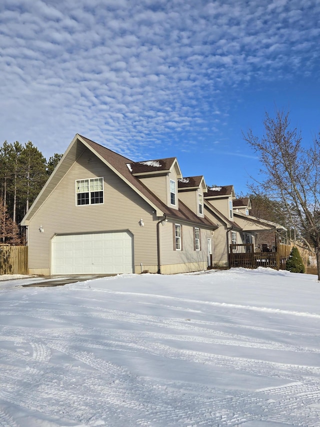 snow covered property with a garage