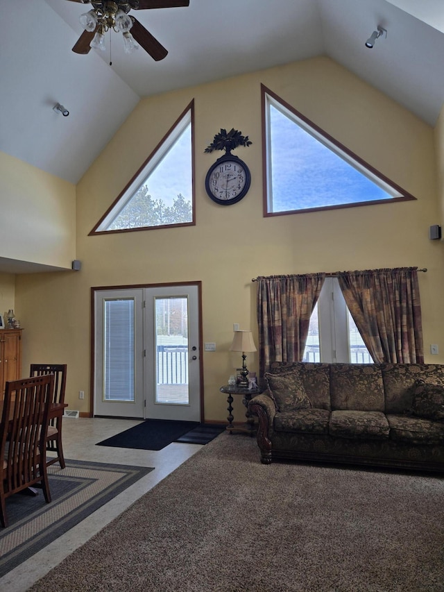 carpeted living room featuring ceiling fan, a wealth of natural light, and high vaulted ceiling