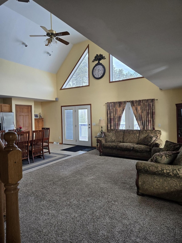 carpeted living room featuring ceiling fan and high vaulted ceiling