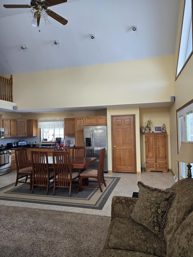 dining room featuring ceiling fan and a high ceiling