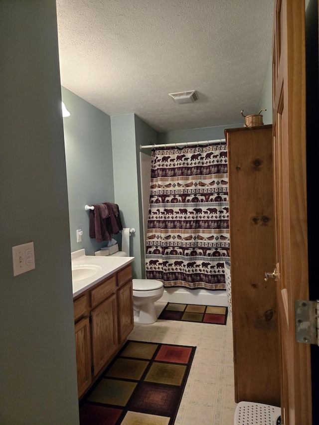 bathroom featuring toilet, vanity, walk in shower, and a textured ceiling