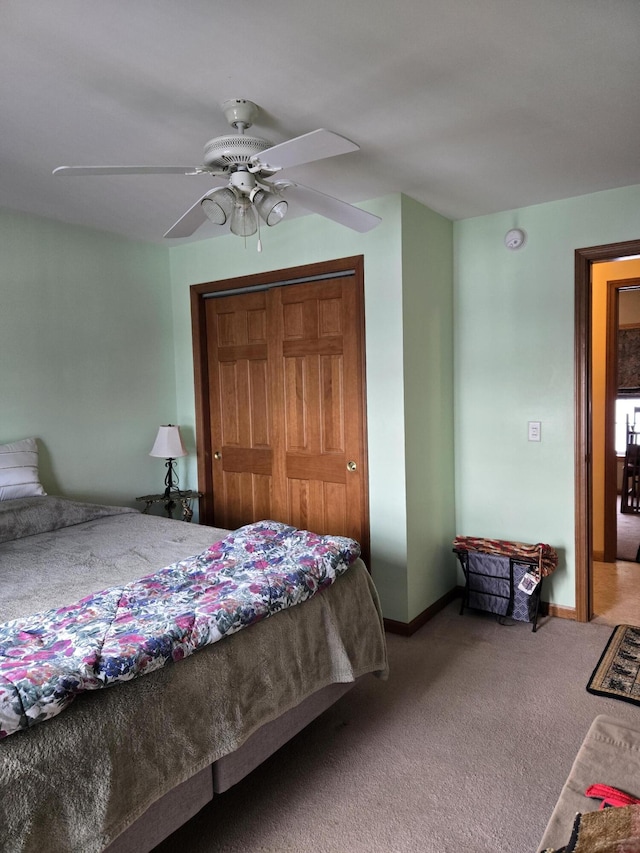 carpeted bedroom with ceiling fan and a closet