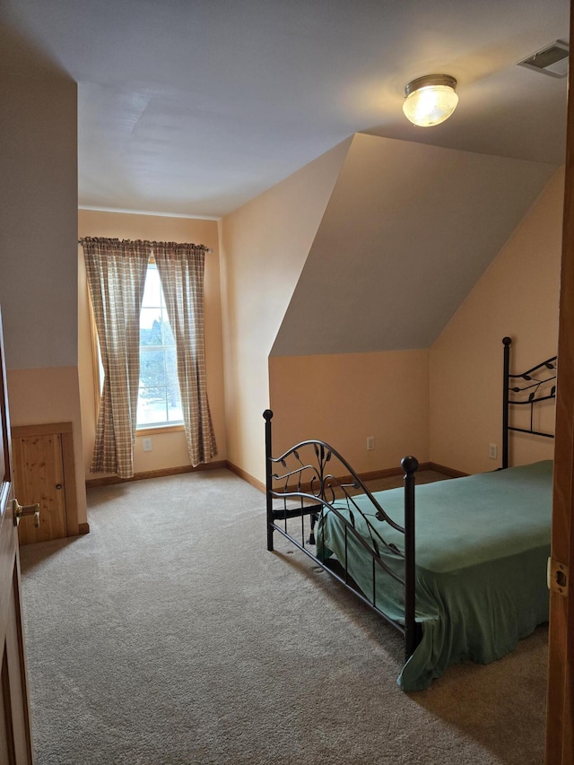 bedroom with carpet flooring and lofted ceiling