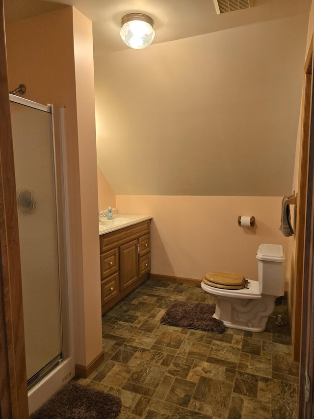 bathroom featuring vanity, toilet, lofted ceiling, and walk in shower