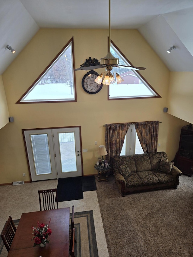 carpeted living room featuring ceiling fan and high vaulted ceiling