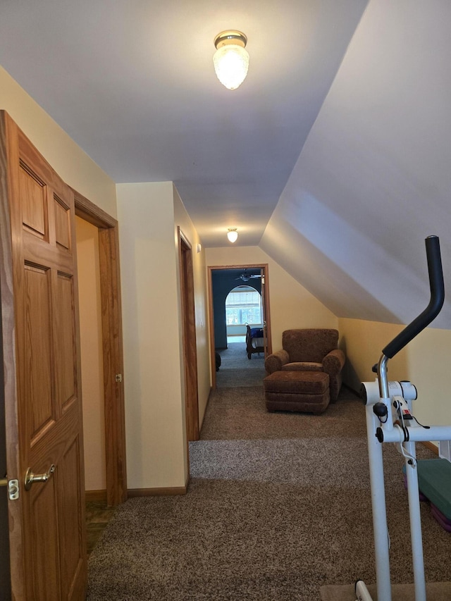 corridor featuring carpet floors and vaulted ceiling