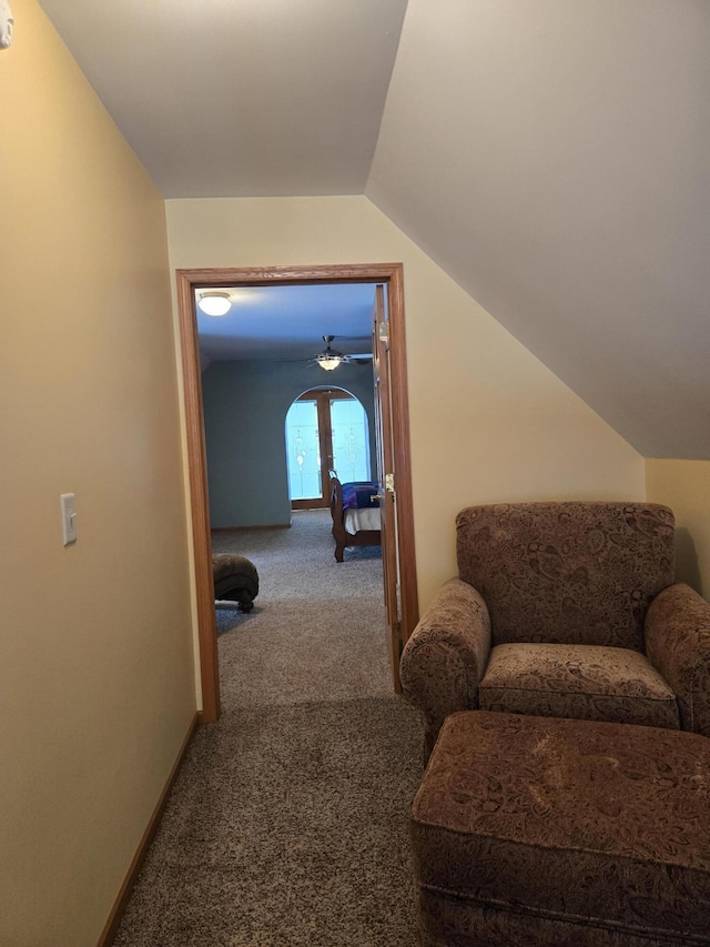 hallway with vaulted ceiling and carpet flooring