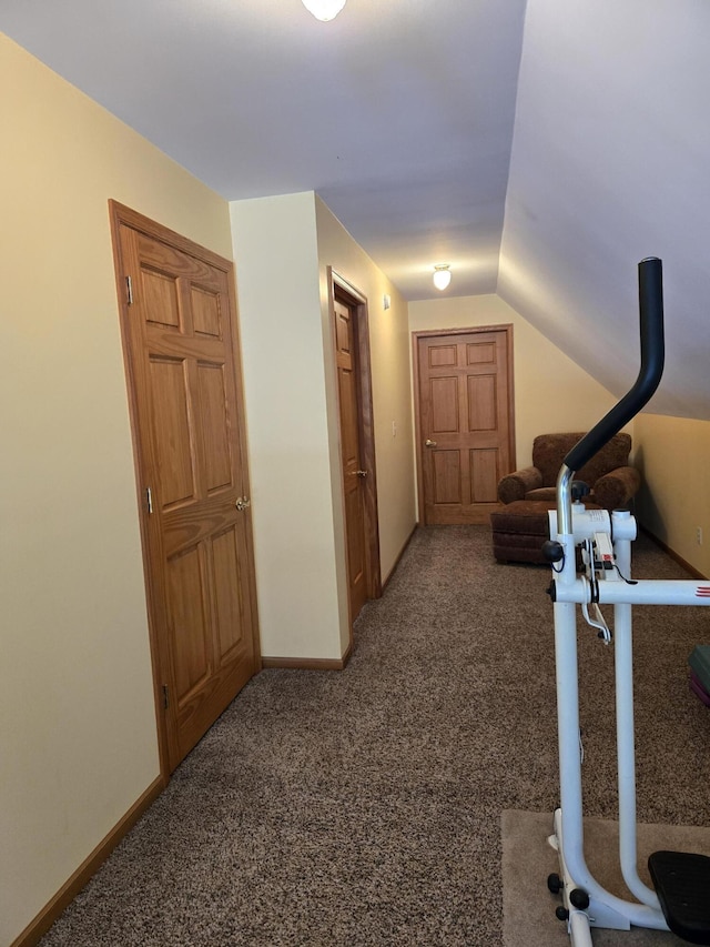 corridor featuring vaulted ceiling and carpet floors