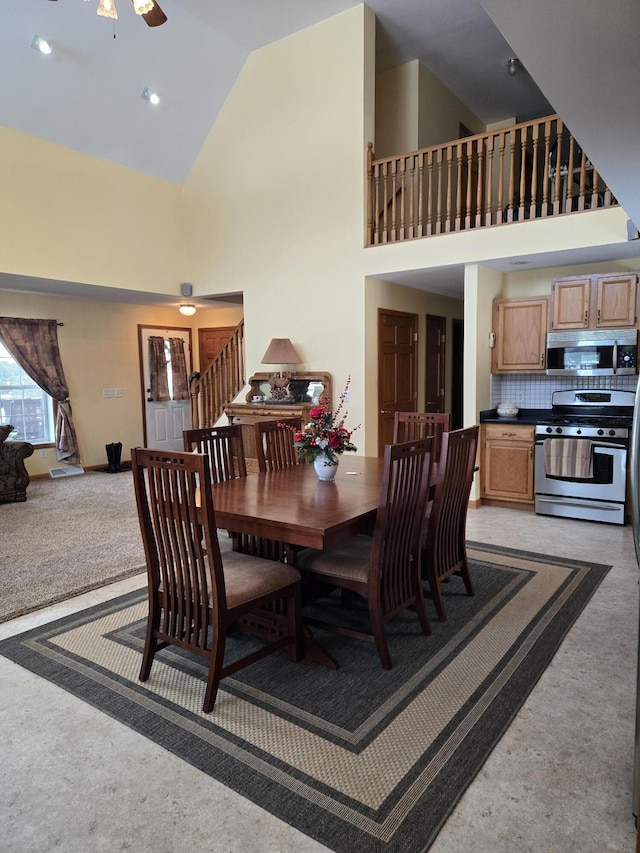 dining room featuring ceiling fan and high vaulted ceiling