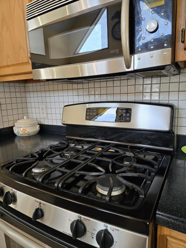 room details with decorative backsplash and stainless steel appliances