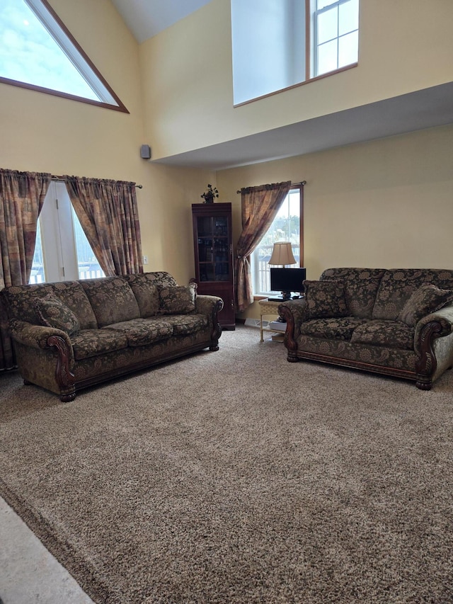 living room with high vaulted ceiling and carpet flooring