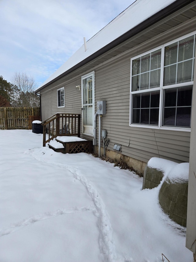 view of snow covered back of property