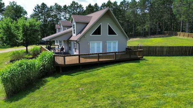 rear view of house with a wooden deck and a lawn