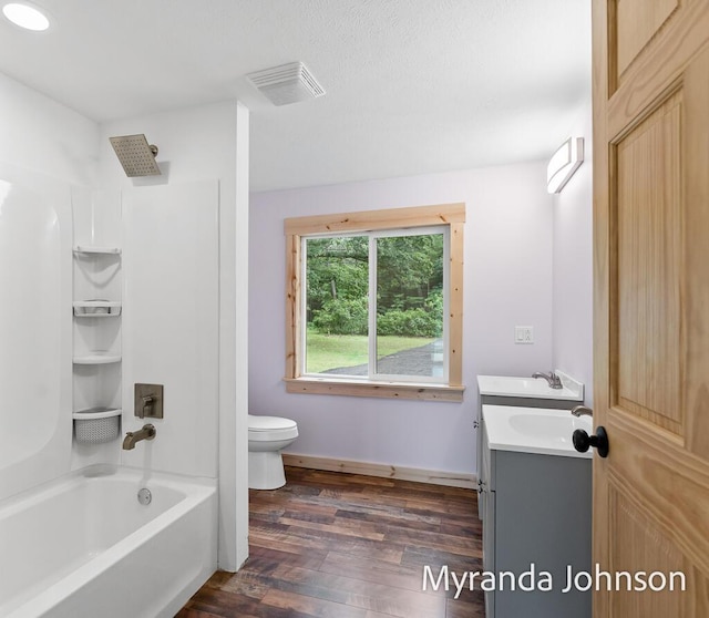 full bathroom featuring hardwood / wood-style flooring, toilet, vanity, and shower / bathtub combination