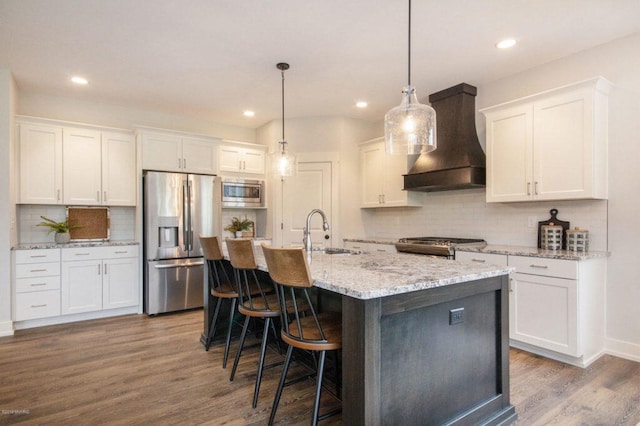 kitchen featuring sink, stainless steel appliances, white cabinets, and custom range hood