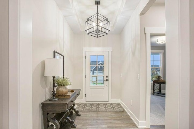 foyer entrance featuring wood-type flooring and a notable chandelier