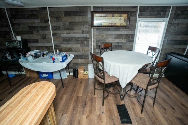 dining room with wooden walls and hardwood / wood-style floors