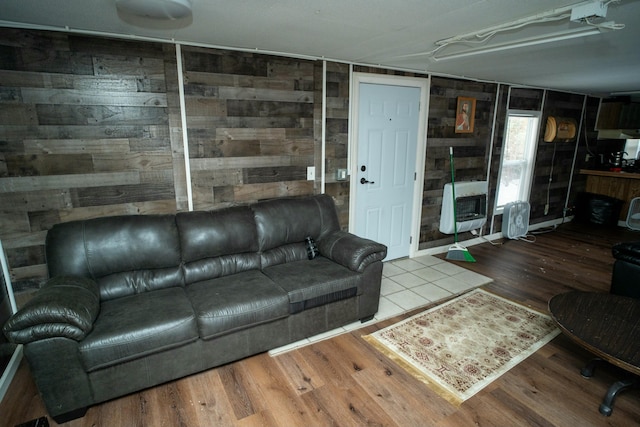 living room featuring hardwood / wood-style flooring, heating unit, and wooden walls