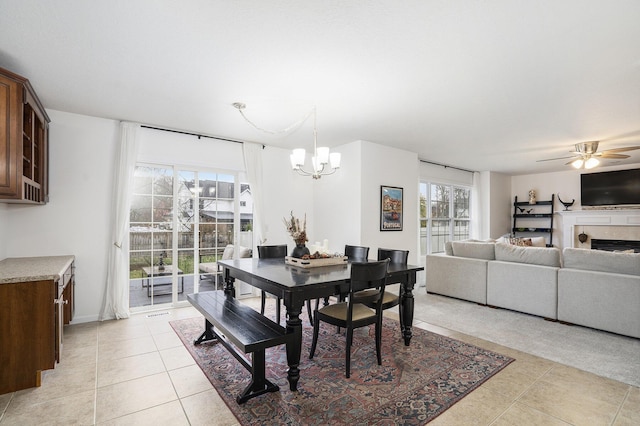 tiled dining area with ceiling fan with notable chandelier