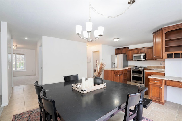 dining room with sink, an inviting chandelier, and light tile patterned flooring