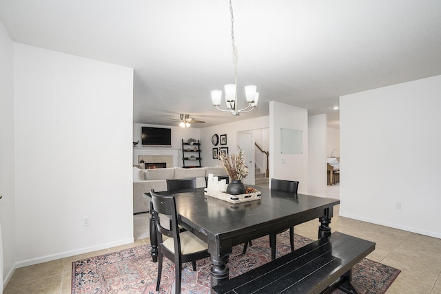 dining room featuring tile patterned flooring and ceiling fan with notable chandelier