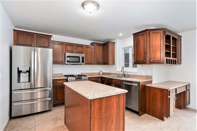 kitchen with a kitchen island, appliances with stainless steel finishes, light tile patterned flooring, and sink