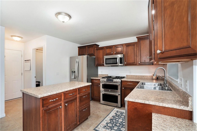 kitchen featuring sink, a center island, light tile patterned floors, and appliances with stainless steel finishes