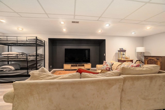 living room featuring a drop ceiling and light hardwood / wood-style flooring