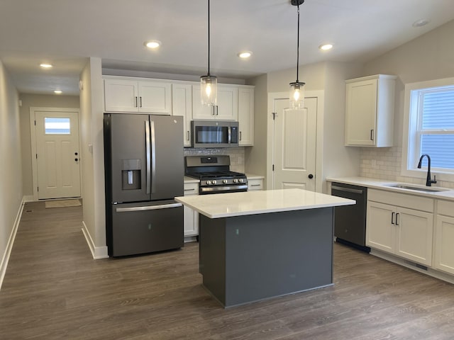 kitchen featuring decorative light fixtures, stainless steel appliances, white cabinets, and sink