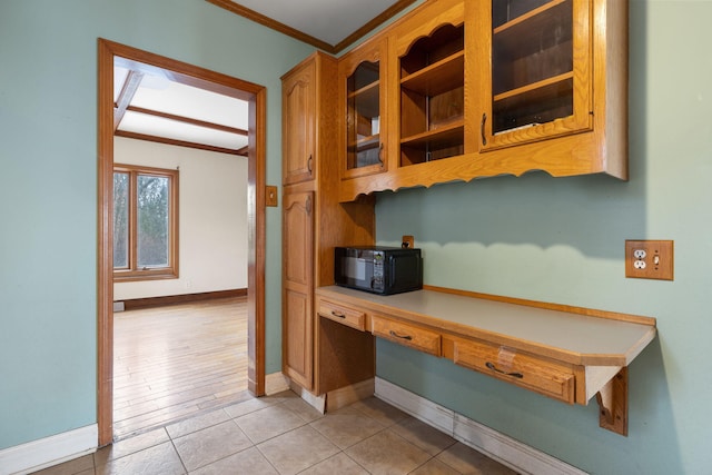 kitchen with built in desk, ornamental molding, and light tile patterned floors