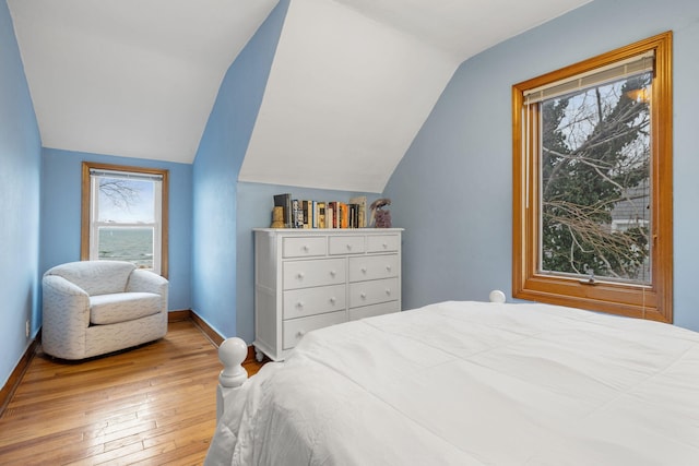 bedroom with vaulted ceiling and light hardwood / wood-style floors