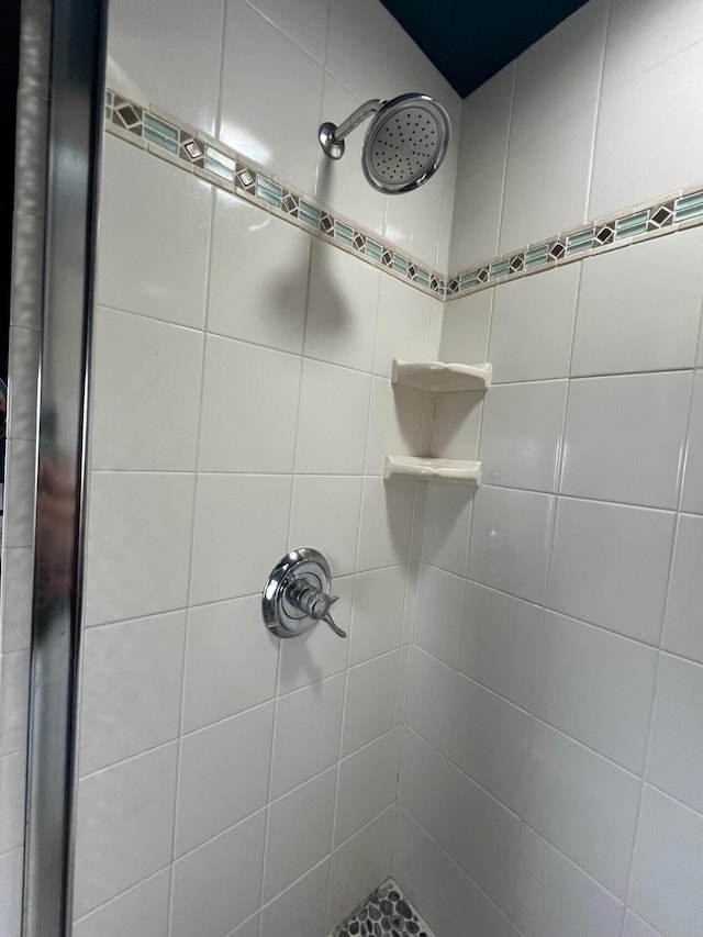 interior details with a tile shower