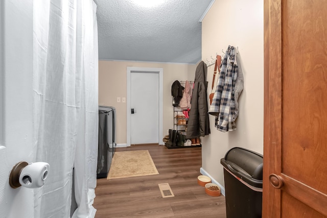 interior space featuring a textured ceiling, wood-type flooring, and washing machine and clothes dryer