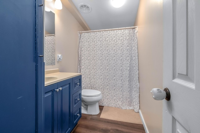 bathroom featuring wood-type flooring, curtained shower, vanity, and toilet