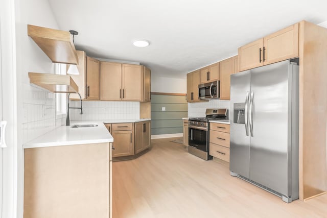 kitchen featuring pendant lighting, sink, stainless steel appliances, light wood-type flooring, and light brown cabinets