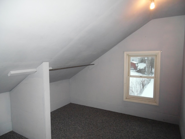 bonus room featuring lofted ceiling and dark colored carpet