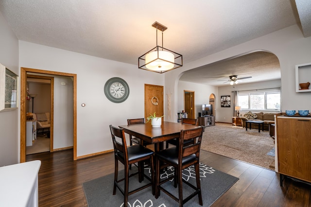 dining space with ceiling fan, dark hardwood / wood-style flooring, and a textured ceiling