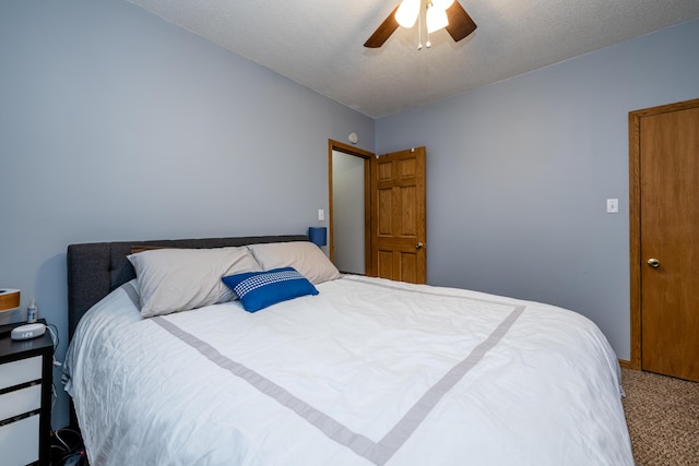 carpeted bedroom with ceiling fan and a textured ceiling