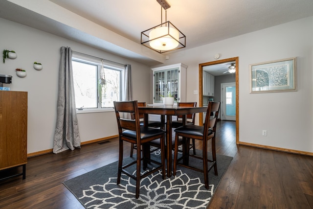 dining area with dark wood-type flooring and ceiling fan