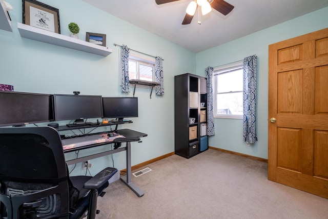 office featuring ceiling fan, light colored carpet, and plenty of natural light