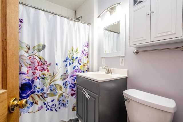 bathroom with toilet, walk in shower, and vanity