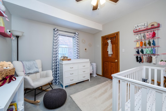 carpeted bedroom featuring ceiling fan and a crib