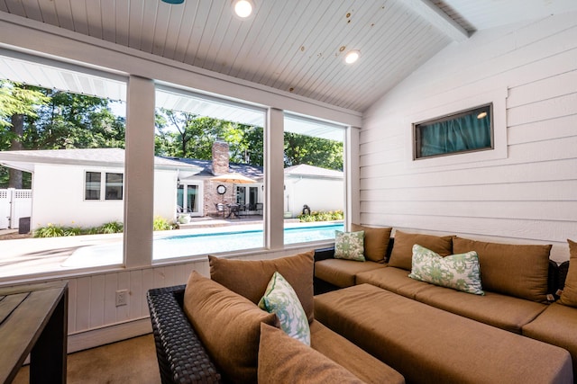 sunroom / solarium featuring lofted ceiling with beams and a healthy amount of sunlight