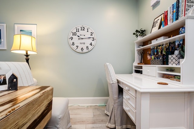 home office with light hardwood / wood-style flooring